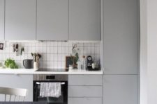 04 a modern light grey kitchen with a white tile backsplash made stand out with black grout