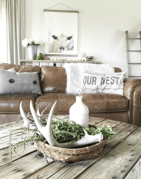 a simple table display with a basket, greenery and whitewashed antlers