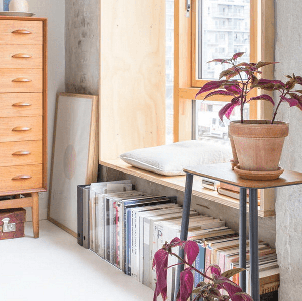 A comfortable reading nook on a windowsill and books under it