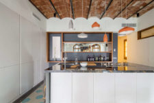05 The kitchen features sleek cabinets, a large kitchen island as a cooking and eating surface