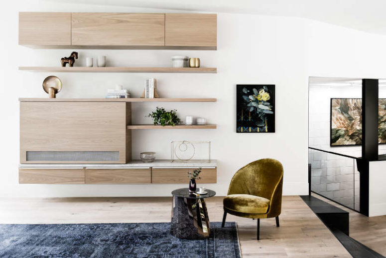 There's a storage unit, a velvet chair and a chic table in the living room