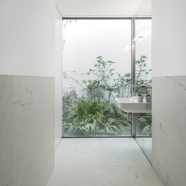 minimalist bathroom with an outdoor view The bathroom is with a view to outdoors, and a tall wall protects the owners from unwanted eyes