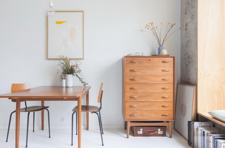 This is a dining zone with a simple dining set and a sideboard of teak