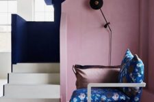 06 a gorgeous sculptural entryway with a dusty pink wall and navy and white staircase