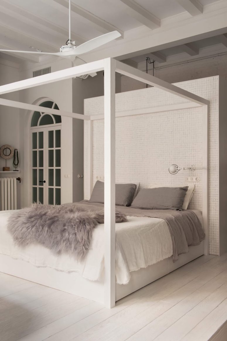 The bedroom features a modern frame bed and a free-standing bathtub right here, opposite the bed