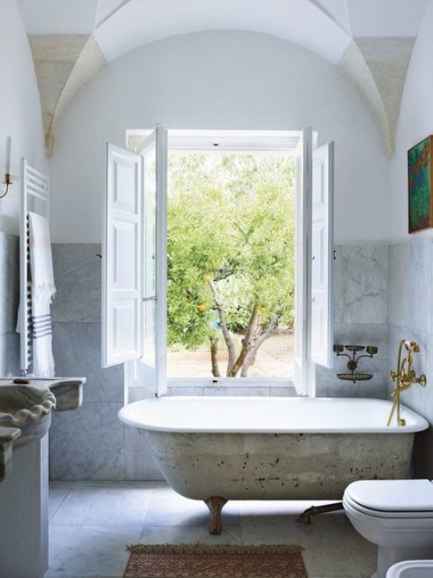 The cast iron tub becomes a centerpiece in this airy space