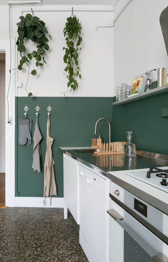 a half painted dark green wall is used as a backsplash and adds a colorful accent