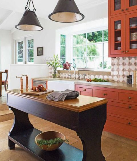 burnt orange cabinets with natural wood countertops and an elegant eggplant kitchen island