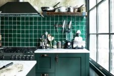 10 vintage dark green cabinets with industrial handles and an emerald tiles backsplash