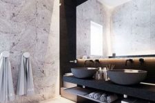 12 a stone wall, marble tiles and a matte black vanity and concrete sinks