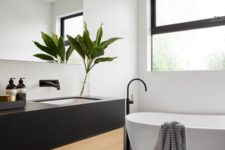 14 a modern space with a black framed window, dark tiles, a black and wood vanity and a tub