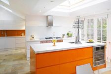 14 an airy all-white kitchen with a bold orange kitchen island and a burnt orange backsplash