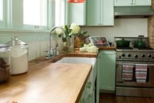 17 a mint green kitchen with coral lamps and natural wood countertops for a vintage feel