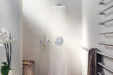 17 a modern space a with wood clad shower, matte white walls and an orchid for a chic touch