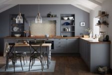 18 a dark grey vintage kitchen with wooden countertops and a matching dining table, which doubles as a kitchen island