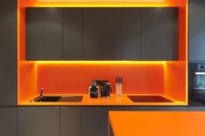 18 a minimalist grey kitchen with bold orange countertops, lights and a backsplash