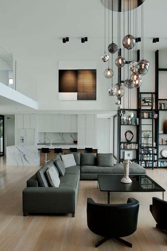 a stylish modern living room with grey furniture, storage units on the walls and a lighting cluster that highlights the ceiling