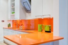 19 a minimalist white kitchen is made bolder with an orange backsplash and countertops