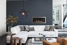 19 monochrome with a black statement wall, white furniture, wooden tables and an amber chair