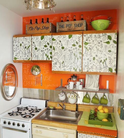 a cheerful kitchen with a leaf print and a bold orange backsplash for a colorful touch