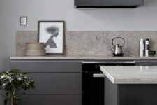 21 a modern sleek dark grey kitchen with a black hood, white countertops and a grey stone backsplash looks very stylish