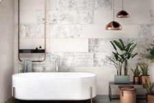23 a chic modern space with neutral tiles, a free-standing bathtub on copper legs, copper lamps and fixtures