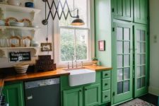 23 bold green cainets for a vintage rustic space look nice with wooden countertops and industrial lighting