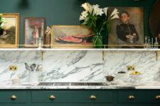 27 dark green cabinets with brass handles and a marble backsplash look just jaw-dropping and bold