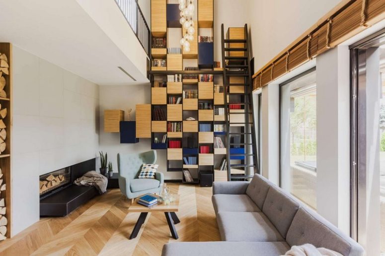 This modern and bold residence features a cool floor to ceiling bookcase and bold touches of blue throughout the interiors