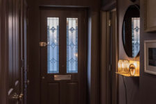 02 The entryway is done in dark shades, with a faux animal head and cool vintage lamps that hint on what’s further