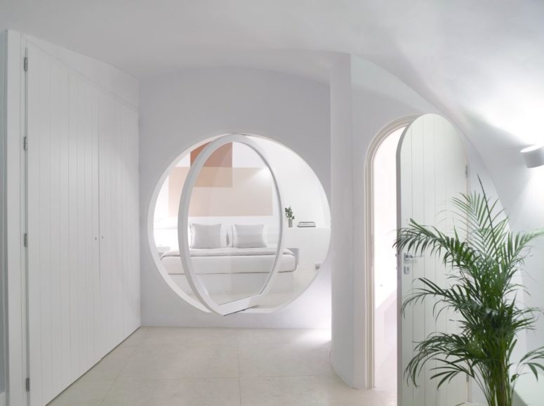 The villa is cave-like, all-white, the materials used in decor are natural and there's a large glass pivot door, which makes the spaces look modern