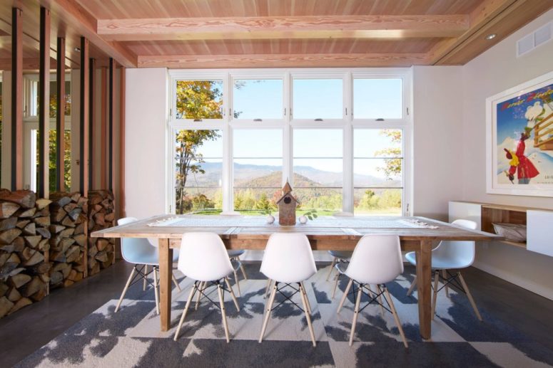 This is a dining space with amazing views, a bold artwork; it's seprated with a stack of firewood from the living room