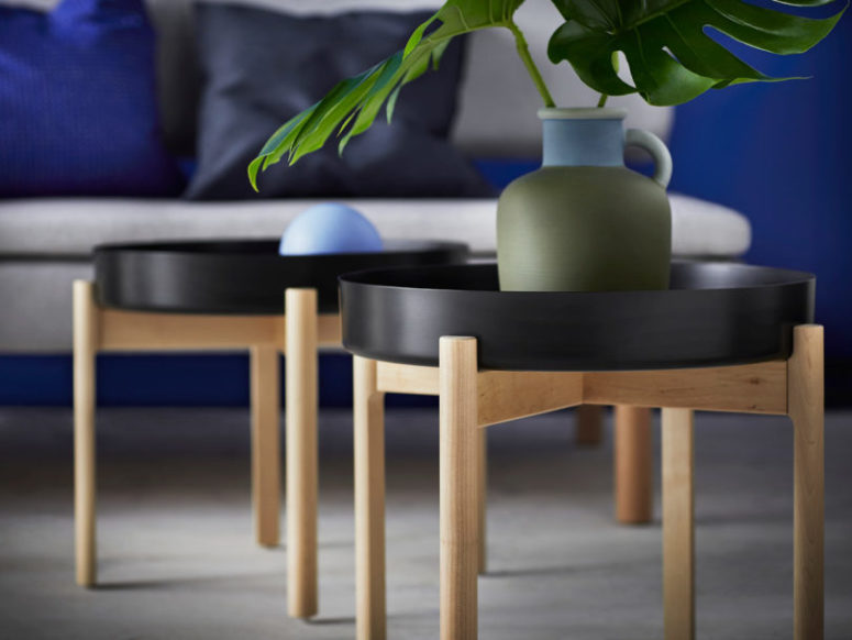Tray style coffee tables are done with black tabletops and wooden legs