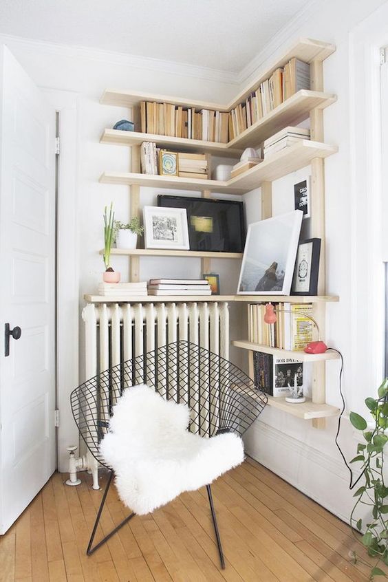 a cozy reading nook with a comfy chair and bookshelves over the radiator is a warm and cozy space