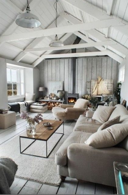 a summer house with a grey wooden wall and a white wooden sloped ceiling for a light and airy space