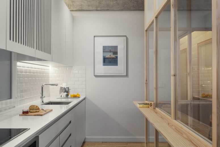The kitchen is done in white - with white tiles, walls and cabinets to make it look airy and large