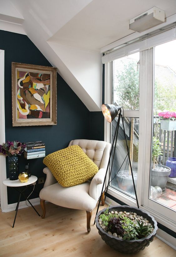 a cozy reading nook by the window, with an artwork, succulents and a small side table