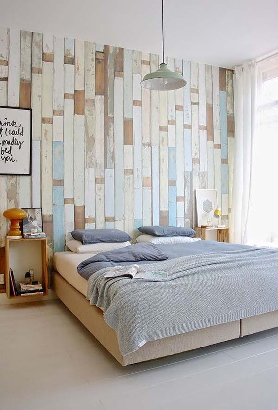 a light and airy bedroom with a reclaimed wood pallet wall in different shades