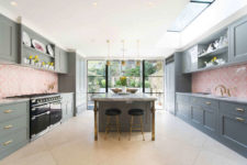 05 The kitchen is done in graphite grey, with pink patterned tile backsplashes and some brass touches