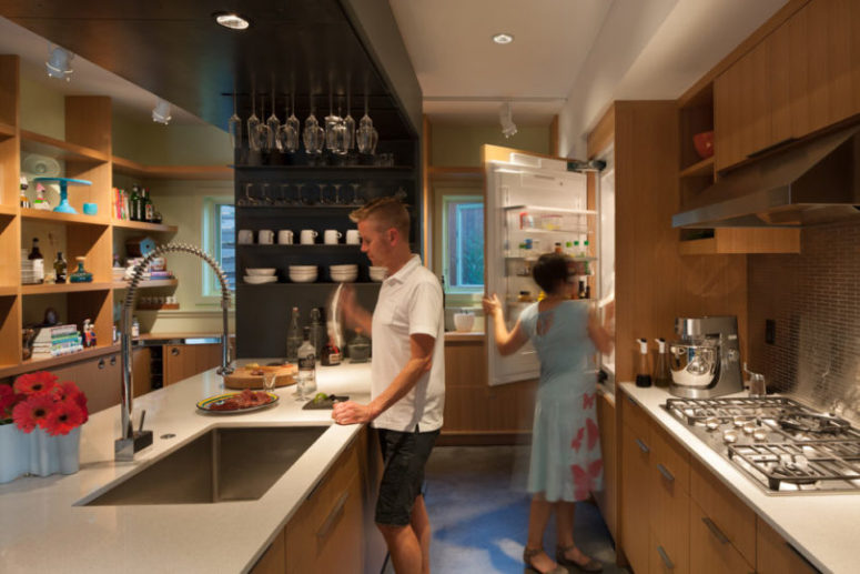 The kitchen is done with light colored wood, with neutral countertops and there are a lot of shelves The kitchen is done with light-colored wood, with neutral countertops and there are a lot of shelves