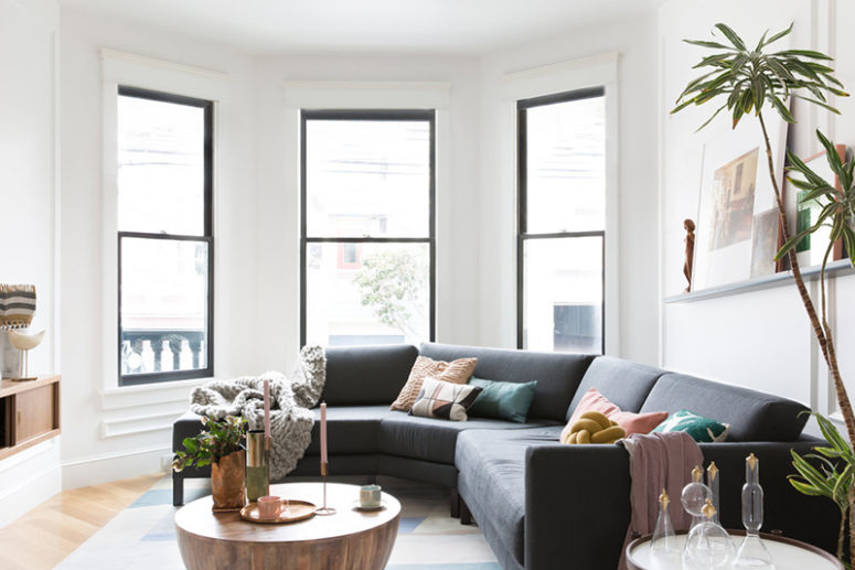 The living room is hexagon shaped, there's a nice selection of furniture in natural wood and black