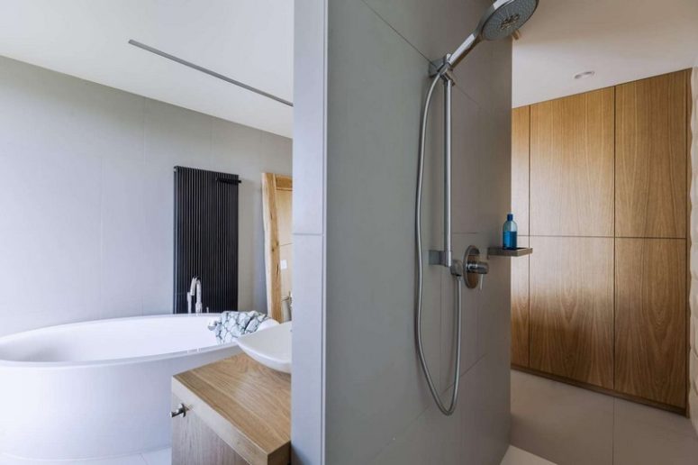 The master bathroom features a free-standing bathtub, a shower and some wooden touches for coziness