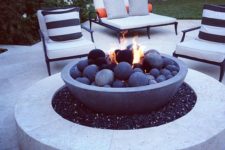 06 a modern bonfire space of white stone with an eye-catchy firepit with stone balls