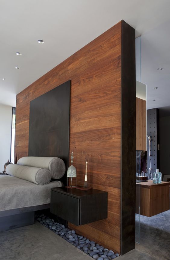 a modern bedroom with a headboard wooden wall and pebbles for a relaxing feel