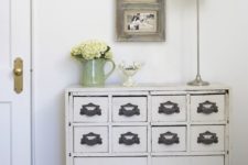 07 a vintage cabinet painted white with refined handles as a chic entryway console