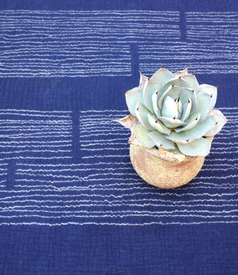 climb is a bold electric blue rug with white embroidery for chic modern rooms