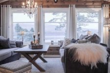 09 a cozy cabin-style living room with a wooden wall and several windows that bring views in