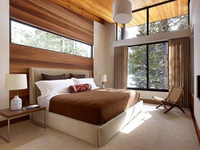 a gorgeous space with a wood clad wall with an additional window for more light and a large window to bring the views in