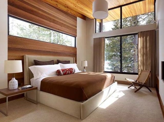 a gorgeous space with a wood clad wall with an additional window for more light and a large window to bring the views in