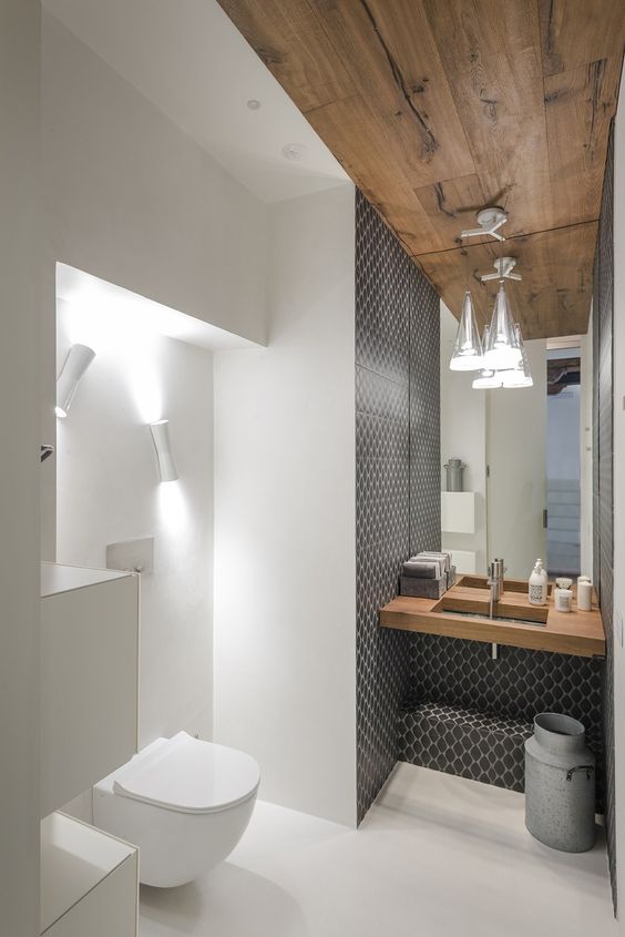 the sink zone is accentuated with grey mosaic tiles, and the toilet zone is lit up